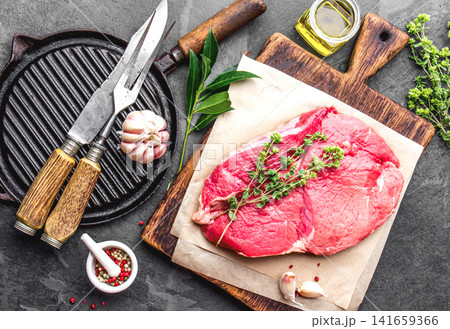 Raw Beef Steak on Wooden Cutting Board with Herbs and Spices Raw Beef Steak on Wooden Cutting Board with Herbs and Spices 141659366