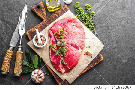 Raw Beef Steak on Wooden Cutting Board with Herbs and Spices 141659367