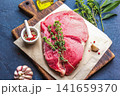 Raw Beef Steak on Wooden Cutting Board with Herbs and Spices 141659370