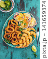 Seafood hot platter baked scallops, fried squid rings and shimps. Top view 141659374