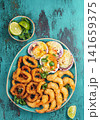 Seafood hot platter baked scallops, fried squid rings and shimps. Top view 141659375
