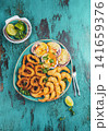 Seafood hot platter baked scallops, fried squid rings and shimps. Top view 141659376