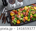Grilled peach and prosciutto salad with green lettuce, balsamic glaze and wine on dark background 141659377