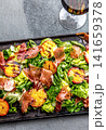 Grilled peach and prosciutto salad with green lettuce, balsamic glaze and wine on dark background 141659378