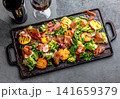 Grilled peach and prosciutto salad with green lettuce, balsamic glaze and wine on dark background 141659379