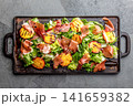 Grilled peach and prosciutto salad with green lettuce, balsamic glaze and wine on dark background 141659382