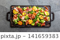 Grilled peach and prosciutto salad with green lettuce, balsamic glaze and wine on dark background 141659383