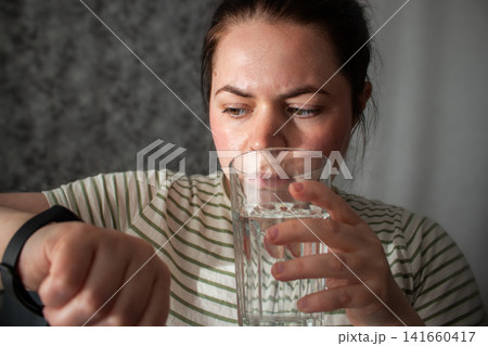 Woman checks health rhythm and pulse then puts watch to sleep. No obsession about data checking. Moving from rigid self-tracking to intuitive balanced tech use Woman checks health rhythm and pulse then puts watch to sleep. No obsession about data checking. Moving from rigid self-tracking to intuitive balanced tech use 141660417