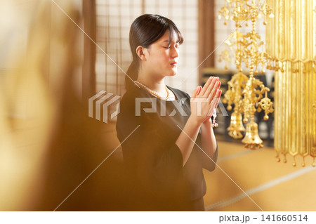目を閉じ合掌する喪服姿の女性の横顔 目を閉じ合掌する喪服姿の女性の横顔 141660514
