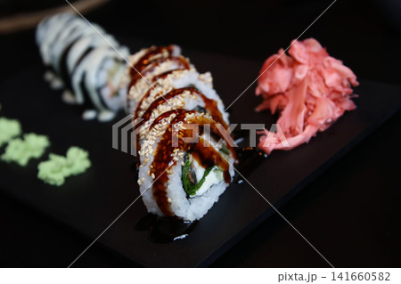 Decadent Glazed Sushi Roll with Sesame Seeds on a Black Slate 141660582