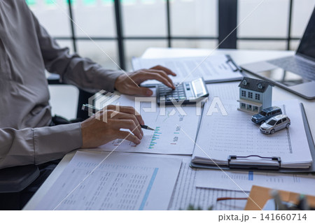 Financial advisor analyzing real estate and car loan budget percentages. Real estate and automotive financial planning concept. 141660714