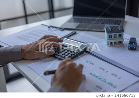 Financial advisor analyzing real estate and car loan budget percentages. Real estate and automotive financial planning concept. 141660715