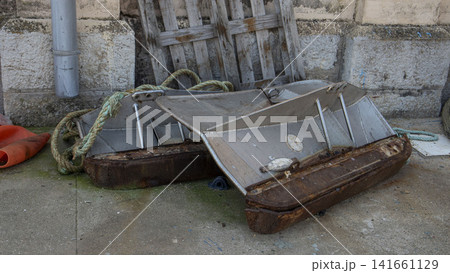 Heavy metal trawl doors with rusty steel bases and green ropes at a commercial harbor Heavy metal trawl doors with rusty steel bases and green ropes at a commercial harbor 141661129