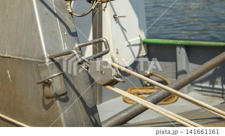 Close up view of a stainless steel pulley block with tension ropes on commercial fishing vessel deck at sea Close up view of a stainless steel pulley block with tension ropes on commercial fishing vessel deck at sea 141661161