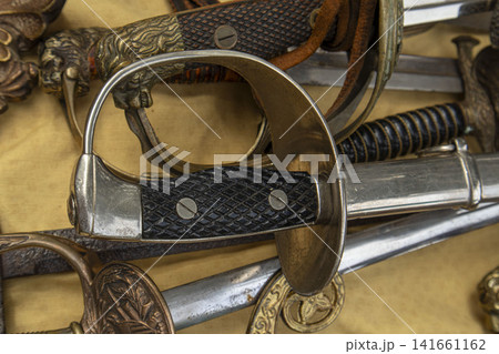 Close up shot of vintage military sword hilt with checkered grip at antique flea market Close up shot of vintage military sword hilt with checkered grip at antique flea market 141661162