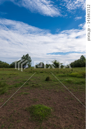 Countryside meadow with silver SUV and wooden shelter under cumulus clouds Countryside meadow with silver SUV and wooden shelter under cumulus clouds 141661512