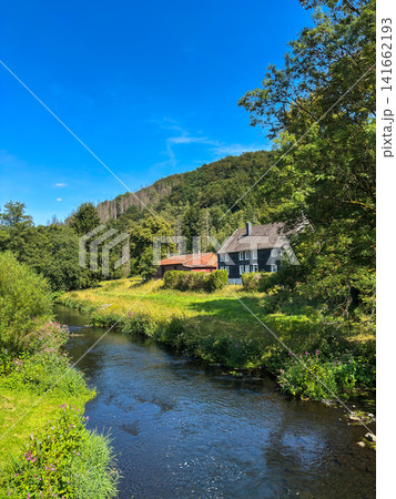 Wupper river with traditional slate farmhouse and forested hills near Beyenburg, Wuppertal, Germany Wupper river with traditional slate farmhouse and forested hills near Beyenburg, Wuppertal, Germany 141662193