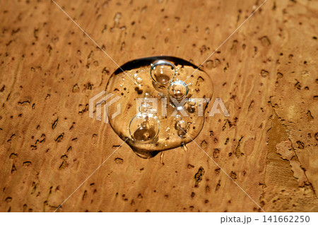 Cosmetic serum liquid gel drop on cork background 141662250