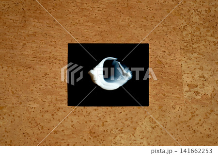Cosmetics serum smear on black against cork background Cosmetics serum smear on black against cork background 141662253