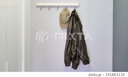 Jacket and Cap Hanging on a Hook Rack in an Entryway Jacket and Cap Hanging on a Hook Rack in an Entryway 141663116