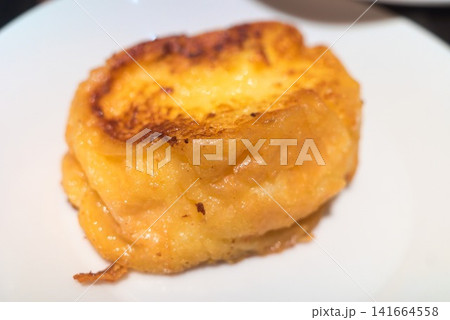 白い皿に盛られたこんがり焼き色のフレンチトーストのクローズアップ 白い皿に盛られたこんがり焼き色のフレンチトーストのクローズアップ 141664558