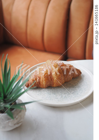 Croissant on a plate in a cafe setting 141665186
