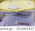 Macro shot of yellow oil droplets floating on water surface liquid separation science experiment cooking oil chemistry concept abstract close up macro photo image background 141665427