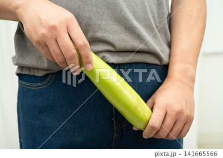 Male stands holding a banana, penis health. Male stands holding a banana, penis health. 141665566