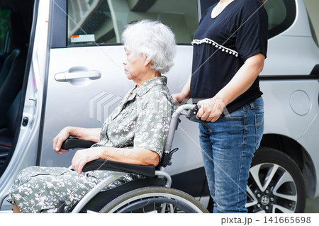 Caregiver help Asian elderly woman disability patient get in her car. Caregiver help Asian elderly woman disability patient get in her car. 141665698