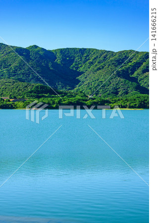 青く穏やかな湖面と深い緑の山々が広がる石垣島底原ダムの美しい風景 141666215