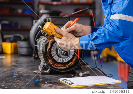 Electrical Maintenance Motor. Technician at Work measuring power meter with Electric motor Electrical Maintenance Motor. Technician at Work measuring power meter with Electric motor 141666311