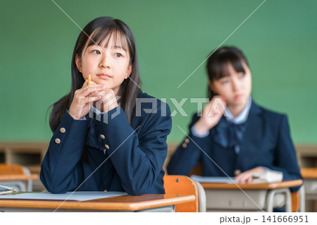 授業中にやる気がなさそうにまだの外を見る小学生,中学生,高校生の女子生徒(無気力,反抗期,不機嫌) 授業中にやる気がなさそうにまだの外を見る小学生,中学生,高校生の女子生徒(無気力,反抗期,不機嫌) 141666951