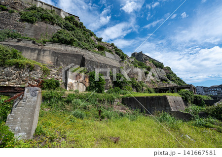 軍艦島の急斜面に建ち並ぶ炭鉱住宅アパートと頑強な擁壁 軍艦島の急斜面に建ち並ぶ炭鉱住宅アパートと頑強な擁壁 141667581