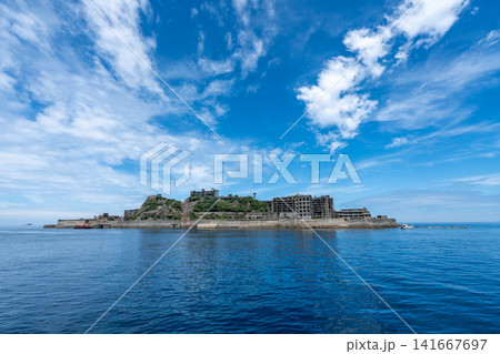 澄み渡る青空と湧き立つ雲の下に浮かぶ軍艦島の島影 141667697