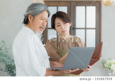 レストランでメニューの相談をするオーナー レストランでメニューの相談をするオーナー 141667959