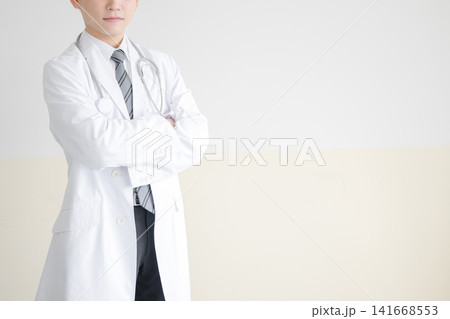 聴診器を下げ腕を組む医師、自信に満ちた立ち姿のイメージ 聴診器を下げ腕を組む医師、自信に満ちた立ち姿のイメージ 141668553