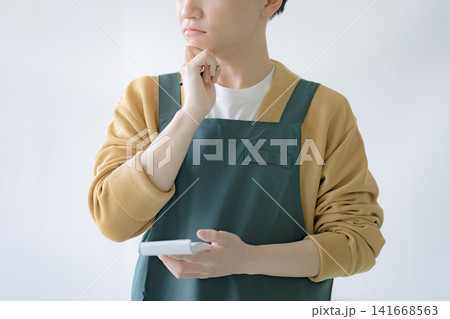 考え込むカフェ店員、メニュー検討のイメージ 141668563