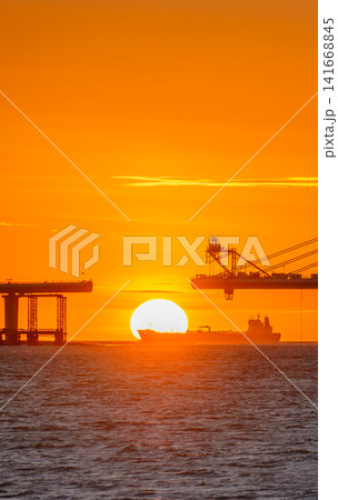 Sunset over Danjiang Bridge and Cargo Ship in Tamsui, Taiwan Sunset over Danjiang Bridge and Cargo Ship in Tamsui, Taiwan 141668845