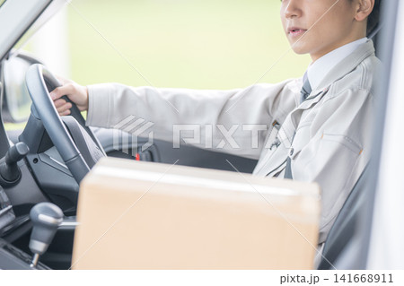 配送用の段ボール箱を積み運転する男性、宅配業務のイメージ 141668911