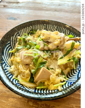 三つ葉たっぷりの手作り親子丼を箸ですくう様子 三つ葉たっぷりの手作り親子丼を箸ですくう様子 141669204