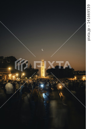 Crowded Marrakech Square at Dusk With Illuminated Minaret Crowded Marrakech Square at Dusk With Illuminated Minaret 141669539