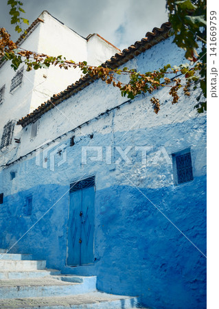 Blue wall along quiet narrow street 141669759