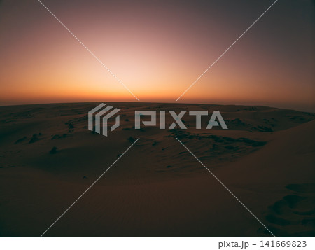 Sunset Over Quiet Desert Dunes 141669823