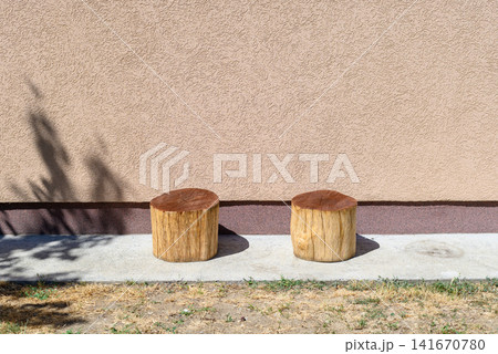 Two wooden stools by a beige wall Two wooden stools by a beige wall 141670780