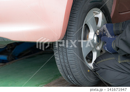 車のタイヤを工具で締める手元、自動車整備のイメージ 車のタイヤを工具で締める手元、自動車整備のイメージ 141671947