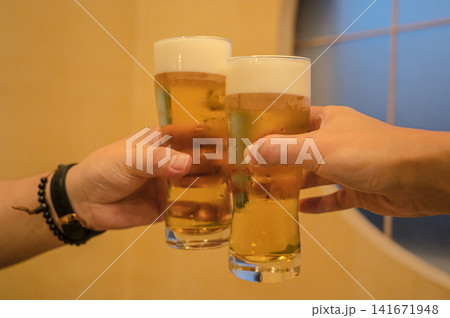 ビールで乾杯する人々の手元、飲み会・お祝いのイメージ 141671948