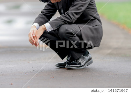 しゃがみこむスーツ姿の男性、悩み・疲労のイメージ 141671967