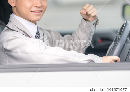 運転中にガッツポーズをする男性、ドライブ・喜びのイメージ 運転中にガッツポーズをする男性、ドライブ・喜びのイメージ 141671977