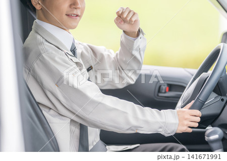 運転中に喜ぶ作業服の男性、営業車・安全運転のイメージ 運転中に喜ぶ作業服の男性、営業車・安全運転のイメージ 141671991