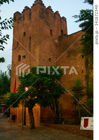 Old mud-brick tower and tree in a Moroccan medina street at dusk Old mud-brick tower and tree in a Moroccan medina street at dusk 141672340